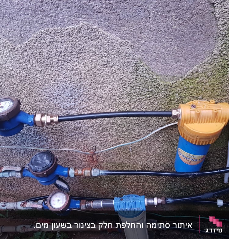 מד מים, צינורות ומסנן מים על קיר